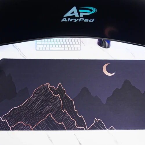 Crescent Moon Mountain desk mat under a curved monitor with keyboard and mouse