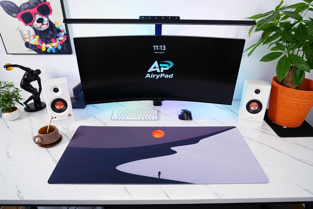 Orange Moon Desert Walker desk mat in a curved monitor setup with keyboard and mouse
