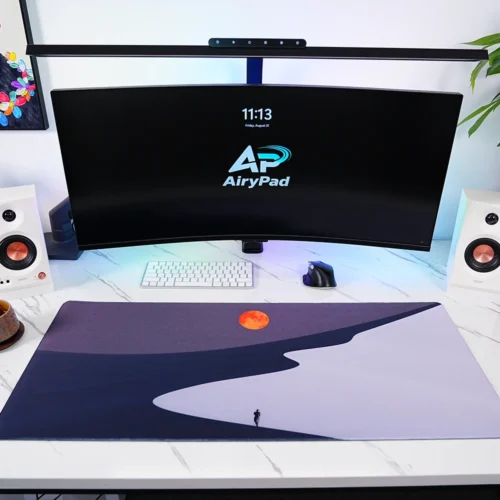 Orange Moon Desert Walker desk mat in a curved monitor setup with keyboard and mouse