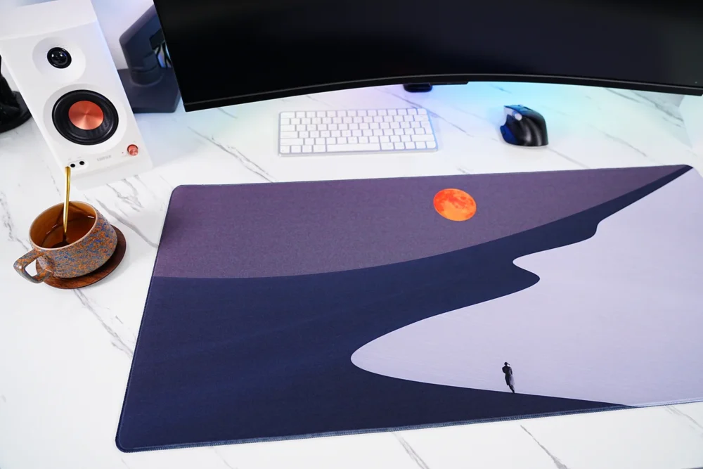 Orange Moon Desert Walker mouse pad close-up showing spill-resistant fabric surface with water droplets