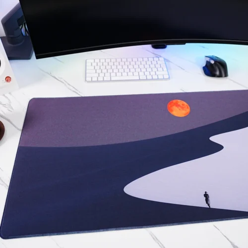 Orange Moon Desert Walker mouse pad close-up showing spill-resistant fabric surface with water droplets