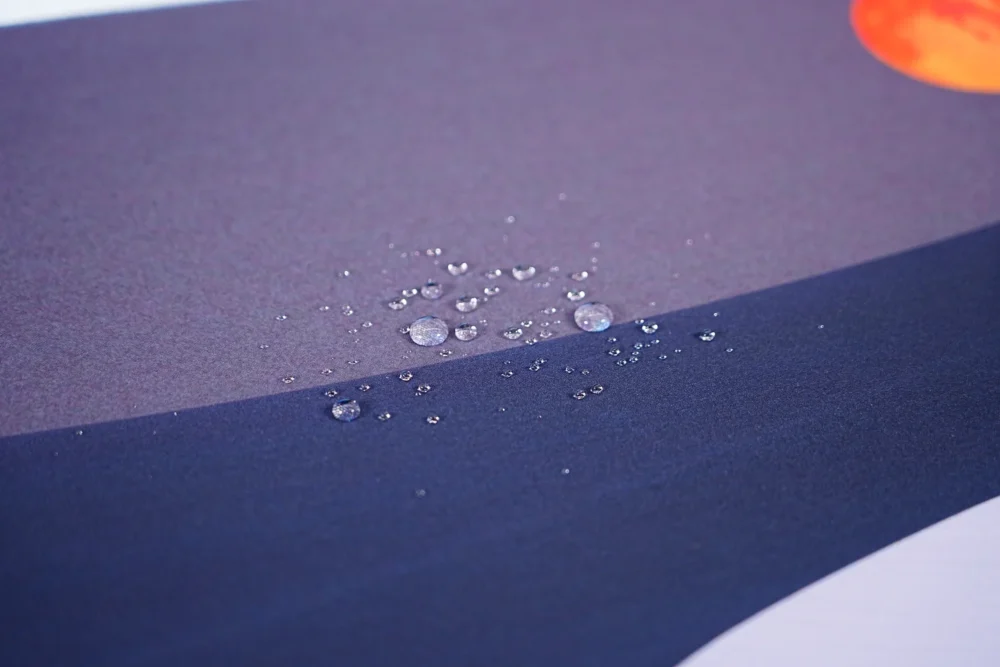 Orange Moon Desert Walker mouse pad close-up showing stitched edge and black rubber base