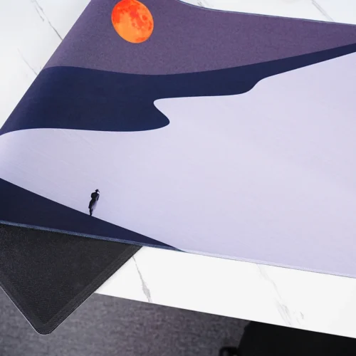 Orange Moon Desert Walker desk mat in a real desktop setup with curved monitor, keyboard and mouse