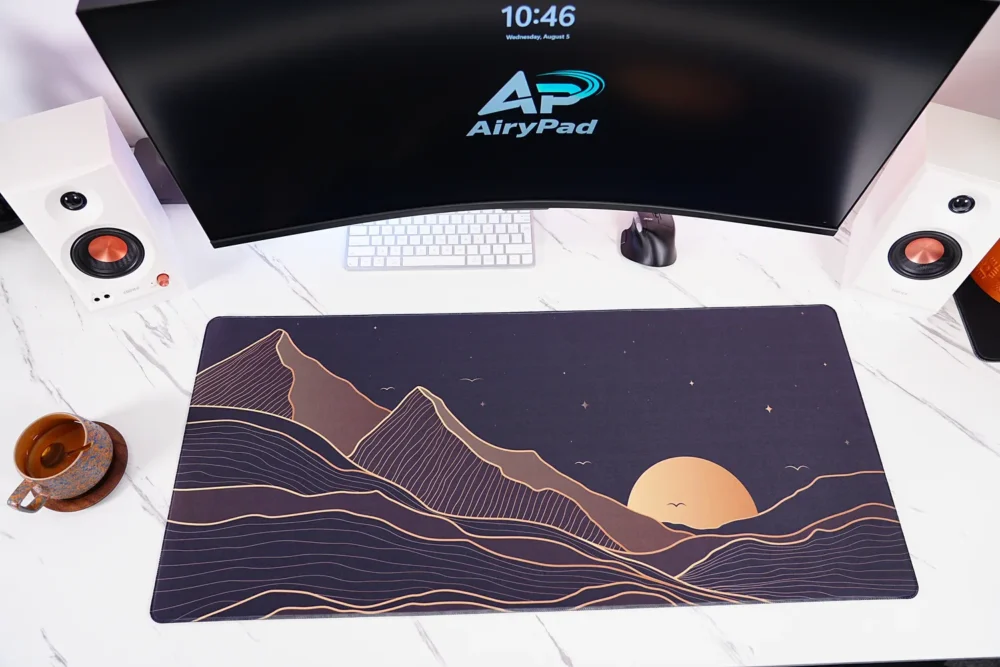 Starry Mountain Sunset desk mat under a curved monitor with keyboard and mouse